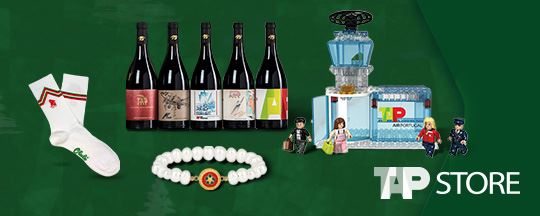 Dark green background image with various products scattered around - socks, wine bottles, a bracelet and toys. On the lower left corner, the "TAP Store" logo.